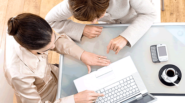 Zwei Leute am Laptop, die sich beraten